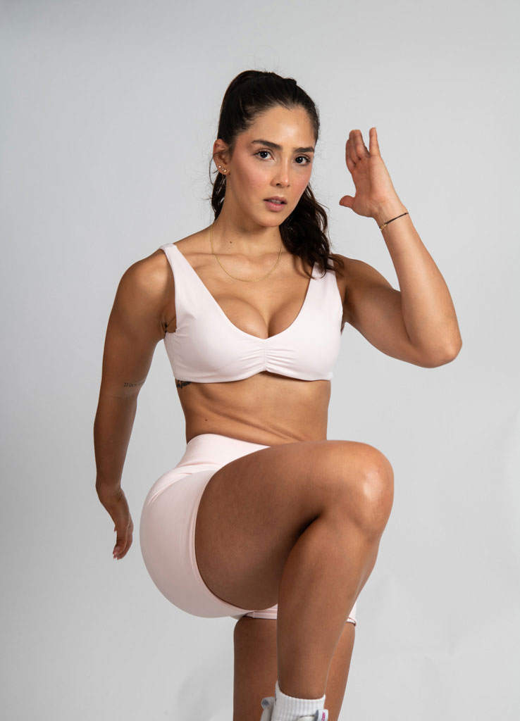 La entrenadora posa con un conjunto de entrenamiento mientras hace ejercicio.